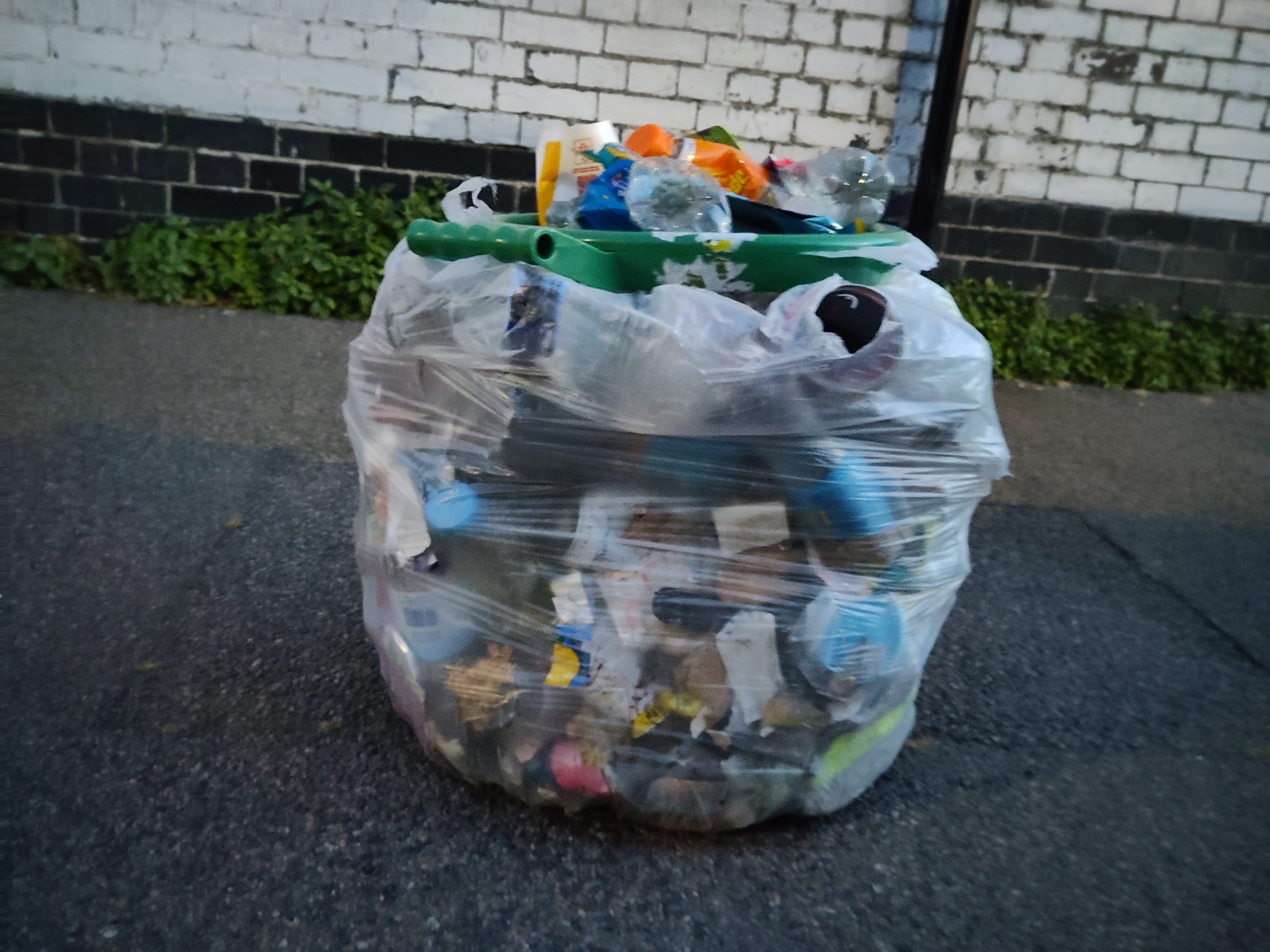 A side on image of a bag full of litter collected from the park